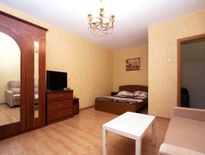 uma sala de estar com uma cama e uma televisão em ApartLux Kantemirovskaya em Moscovo
