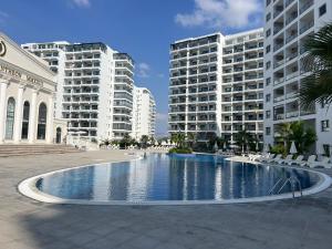 a large swimming pool in front of some buildings at Caesar Resort Didious in Iskele