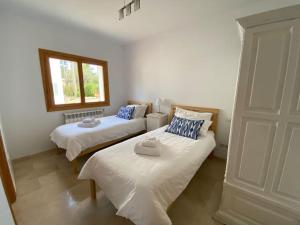 two beds in a room with a window at 5 bedroom villa with pool Puerto Pollenca Majorca in El Port +31 photos