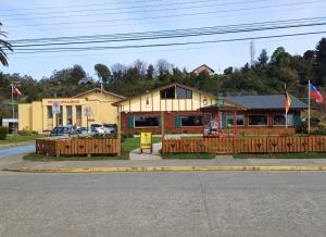 a building on the side of a street with a fence at Cabaña en Frutillar in Frutillar