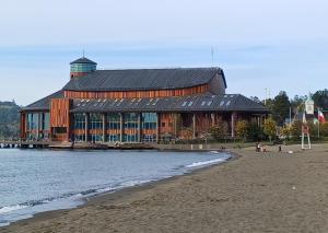 a large building sitting on the beach next to the water at Cabaña en Frutillar in Frutillar