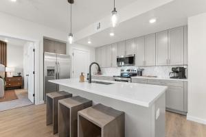 een keuken met een grote witte bar en krukken bij Paradise in the Sand condo in St. George