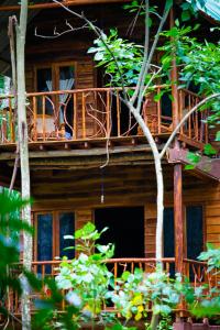 a wooden house with a balcony and trees at Ella Ecolodge in Ella