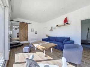 un soggiorno con un divano blu e un tavolo di Maison Bord de Plage avec Piscine, Sauna, Bains à Remous, Volley a Plouguerneau