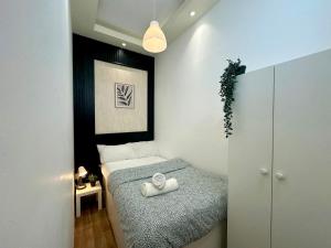 una piccola camera da letto con un letto con asciugamani sopra di Nomad Partition Room in Barsha Heights 3 mins to ICM Metro a Dubai