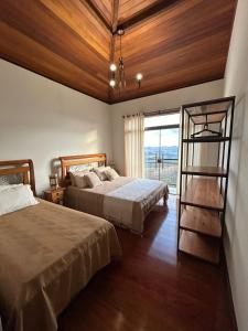 two beds in a room with a window at Casa Tramonto in Lavras Novas