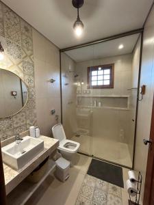 a bathroom with a toilet and a sink and a shower at Casa Tramonto in Lavras Novas