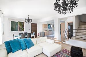 a living room with a white couch and a chandelier at Seaspray Villa in Protaras
