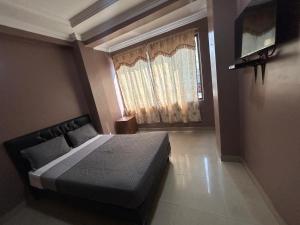 a bedroom with a bed and a window at Hotel Caribe in Guayaquil