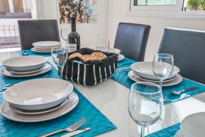 a table with plates and glasses and a bottle of wine at Seaspray in Protaras