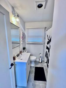 a bathroom with a white sink and a toilet at Comfortable 3BR Close to All in Dayton +8 photos