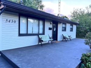 two benches sitting on the side of a house at Comfortable 3BR Close to All in Dayton