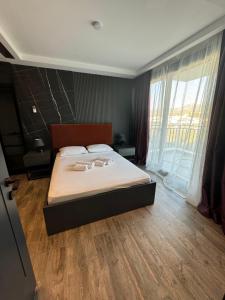 Un dormitorio con una cama grande con una ventana grande. en Isıtmalı Havuzlu Lüks Villa, en Kusadasi