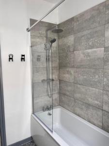 a bathroom with a shower and a bath tub at Stylish Retreat near Birkenhead & Liverpool Your Cozy Home Away From Home in Wallasey +46 photos