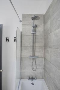 a bathroom with a shower with a tub and a sink at Stylish Retreat near Birkenhead & Liverpool Your Cozy Home Away From Home in Wallasey