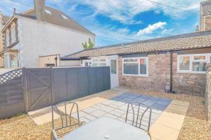 滨海韦斯顿Clifton Sands的有篱笆的房子，露台上有两把椅子