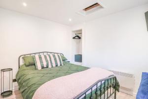 a bedroom with a bed with a green comforter at Clifton Sands in Weston-super-Mare