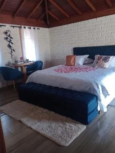 Un dormitorio con una cama grande y una mesa. en Pousada Pôr do Sol, en Monte Verde