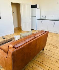 a brown leather couch sitting in a living room at ARK Apartments in Echuca