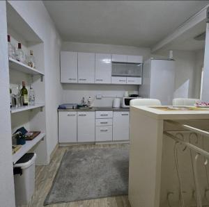 a kitchen with white cabinets and a counter top at Apartment Center 23 in Podgorica +9 photos