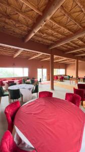 a room with a red bed and tables and chairs at Auberge Famille Benmoro in Skoura