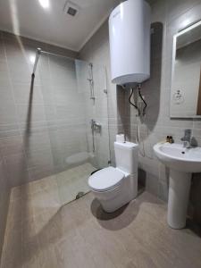 a bathroom with a toilet and a sink and a shower at Batumi Seaside Apartments in Angisa +28 photos