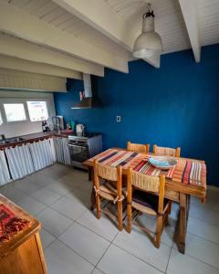 a dining room with a wooden table and chairs at Hermosa casa de campo a 100 mts del mar in Chapadmalal