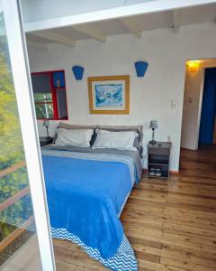 a bedroom with a bed with a blue comforter at Hermosa casa de campo a 100 mts del mar in Chapadmalal