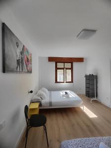 a white room with a bed and a picture on the wall at A de Maritina - Tres Marias Apartaments in Redondela