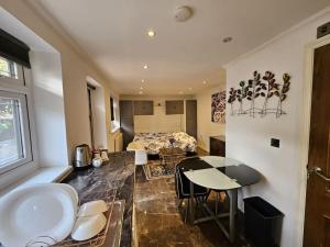 a room with a bed and a table and a kitchen at Spacious Guest Suite - Harrow in London