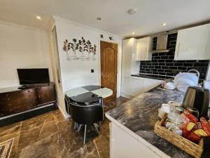 a kitchen with a counter and a table in it at Spacious Guest Suite - Harrow in London