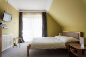 a bedroom with a bed and a large window at Tea Apartman Balatongyörök in Balatongyörök