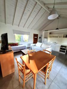 a living room with a table and a couch at Casas Criollas in Chapadmalal +20 photos