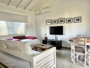 a living room with a couch and a tv at Casas Criollas in Chapadmalal