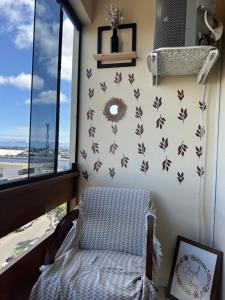 カパン・ダ・カノアにあるApto 604 vibesの椅子と窓が備わる客室です。