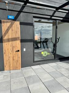 ein Raum mit einer Tür und einem Fenster und einem Fitnessstudio in der Unterkunft Loft Cool Universal in Bogotá