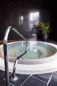 uma banheira de hidromassagem com torneira na casa de banho em Lanes Hotel em Yeovil