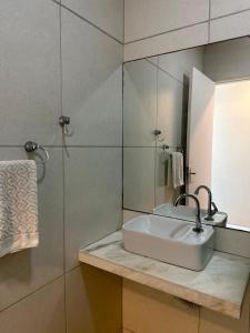 a bathroom with a sink and a mirror at Aloha Pousada Maceió in Maceió