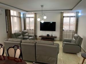 a living room with couches and a flat screen tv at Mubi House in Kinshasa