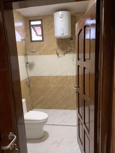 a small bathroom with a toilet and a window at Mubi House in Kinshasa