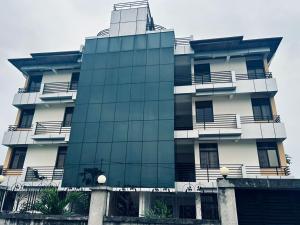 a tall white building with a glass facade at Mubi House in Kinshasa +2 photos