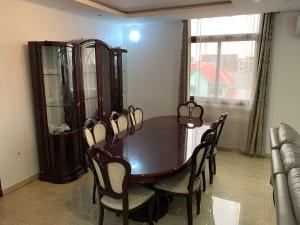 a dining room with a wooden table and chairs at Mubi House in Kinshasa