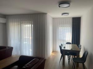 a living room with a table and chairs and a couch at Hana's Apartment in Peje