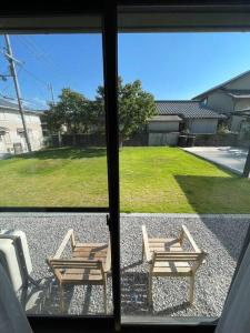 Una vista de un patio con dos bancos desde una ventana. en Hiei Mountain House, en Otsu