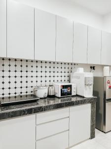 a white kitchen with white cabinets and appliances at Casa Kaharo 2 in Kampong Pak Sabah +14 photos