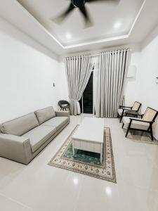 a living room with a couch and a table at Casa Kaharo 2 in Kampong Pak Sabah +14 photos