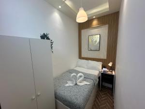 迪拜Quiet Partition Room in Tecom Barsha Heights的小房间,配有带2条白色毛巾的床