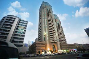迪拜Quiet Partition Room in Tecom Barsha Heights的两座高楼,有汽车停在城市