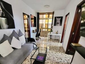 ein Wohnzimmer mit Sofa und Tisch in der Unterkunft Affordable holiday accommodation for large families and groups at Las Canteras beach with 3 Bedrooms and Free Parking in Las Palmas de Gran Canaria