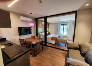 a living room with a kitchen and a living room with a table at Room Hotel Wanderlust in Campos do Jordão